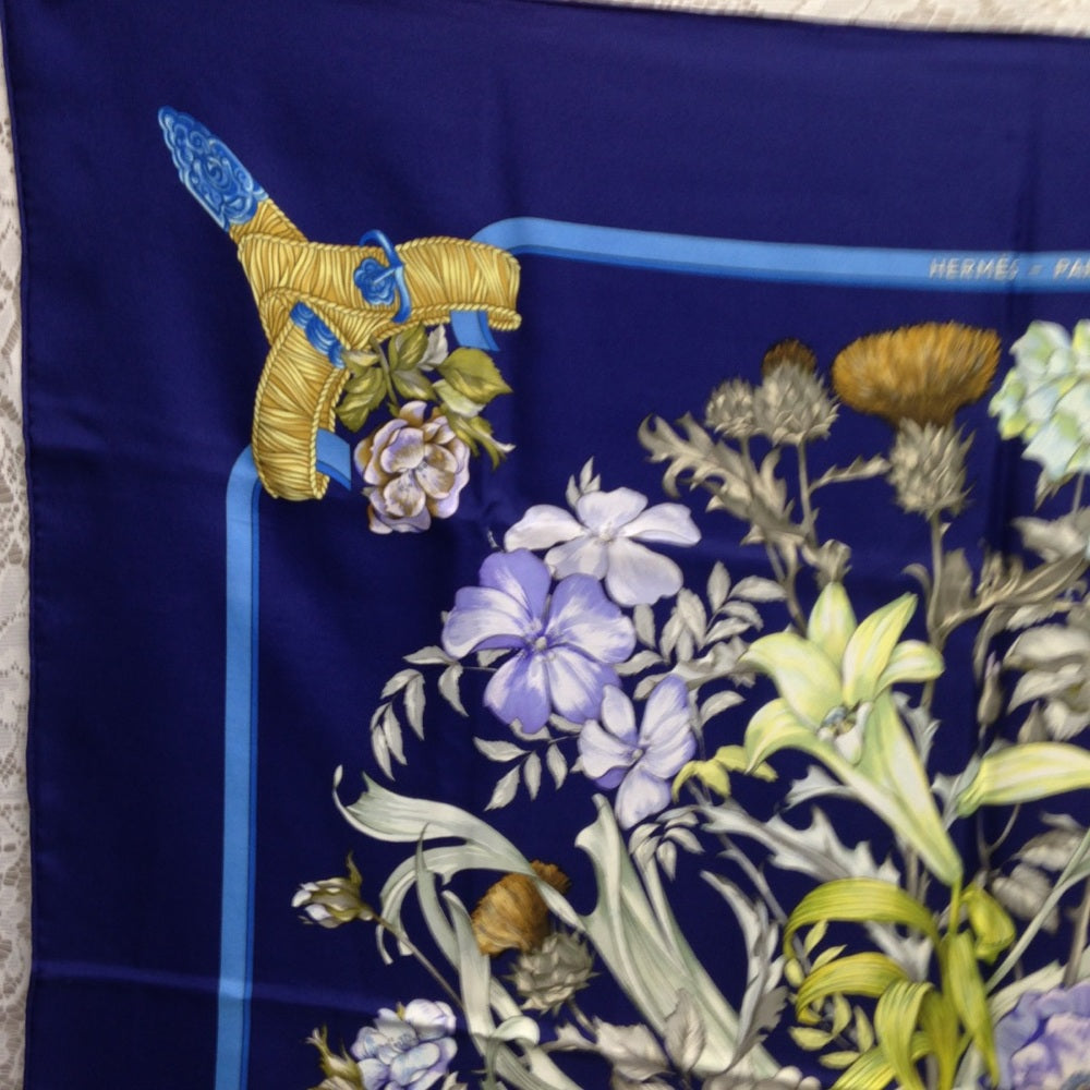 Hermes Regina Floral Scarf over a Blue Backgound