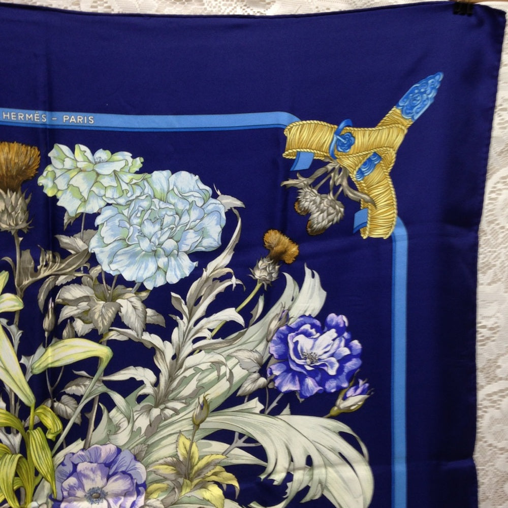Hermes Regina Floral Scarf over a Blue Backgound