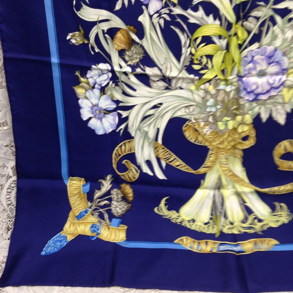 Hermes Regina Floral Scarf over a Blue Backgound