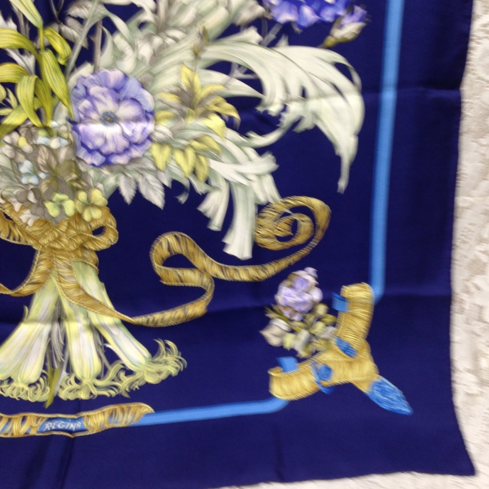 Hermes Regina Floral Scarf over a Blue Backgound