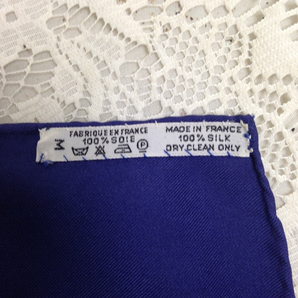Hermes Regina Floral Scarf over a Blue Backgound