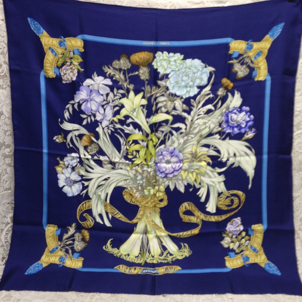 Hermes Regina Floral Scarf over a Blue Backgound